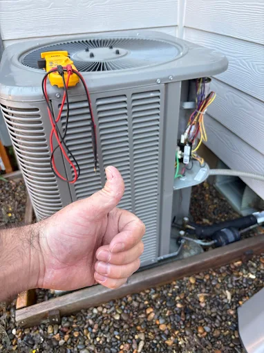 Salem Oregon AC maintenance technician performing air conditioning tune-up service with thumbs up approval