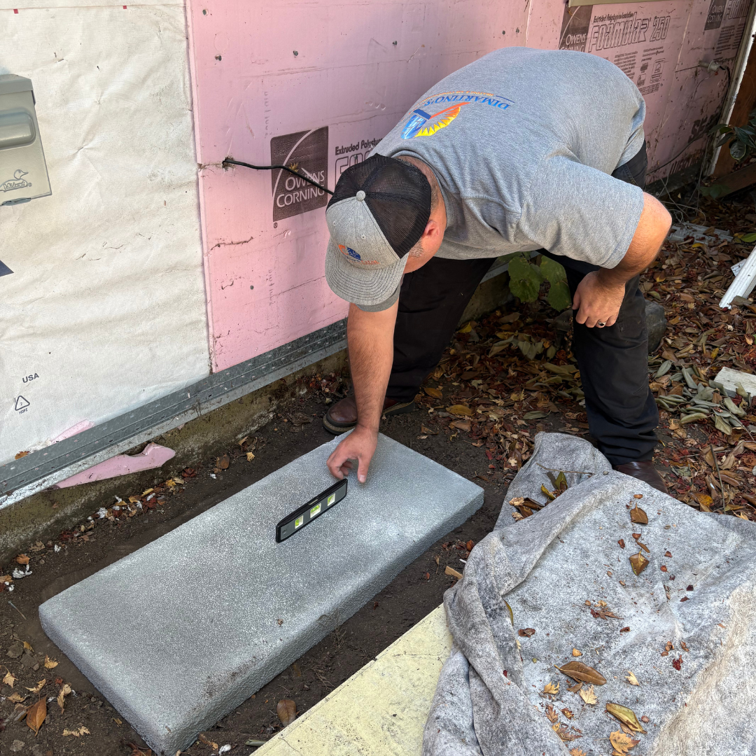 Professional HVAC technician using precision tools to prepare outdoor unit installation pad in Salem Oregon