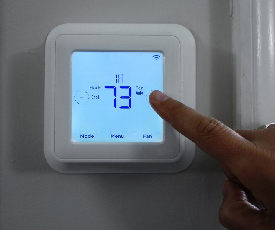 Hand adjusting thermostat set to cool mode at 78 degrees for AC troubleshooting