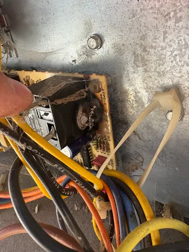 DiMartino's HVAC technician working on AC system electrical components and wiring during repair service in Salem Oregon